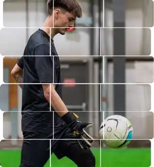 Indoor soccer goalkeeper in black kit controlling a ball during training